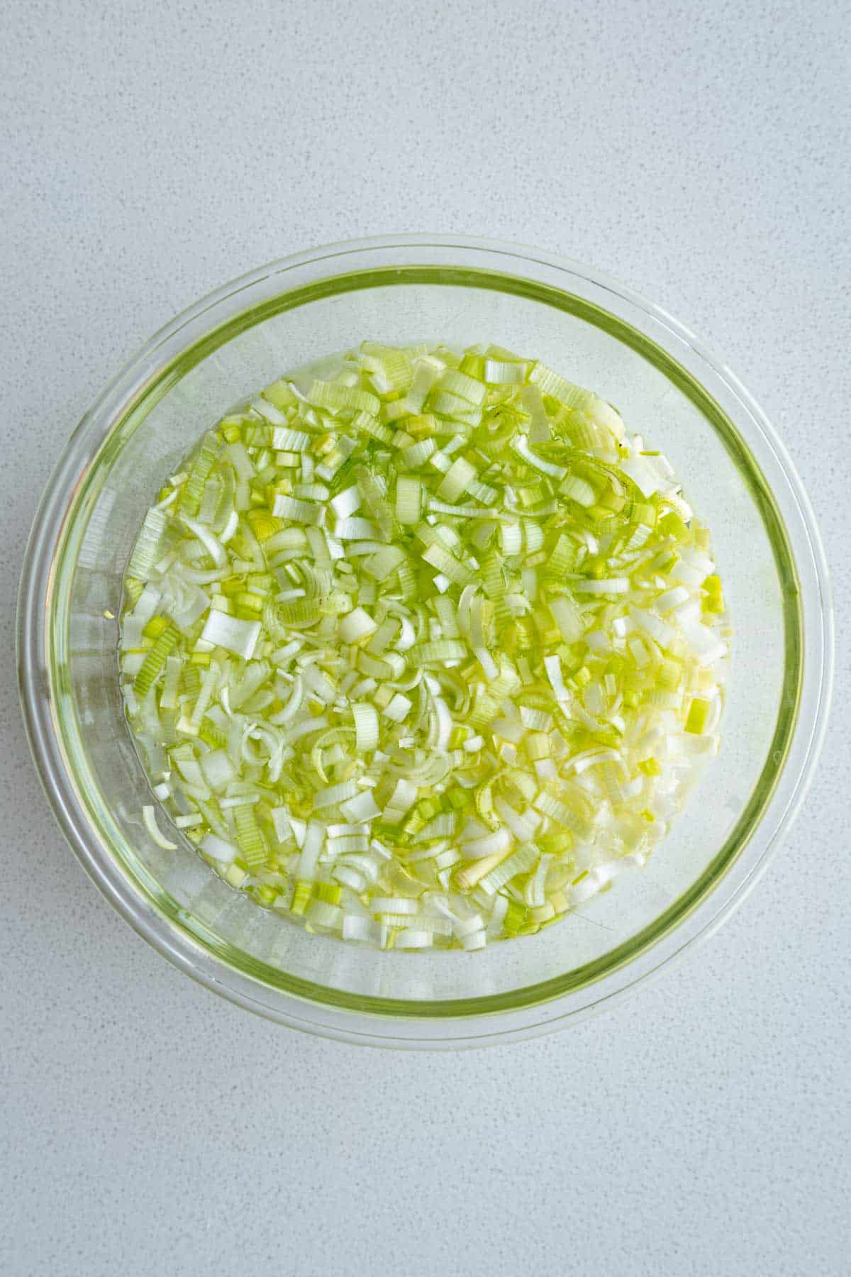 Chopped leeks in a bowl of water.