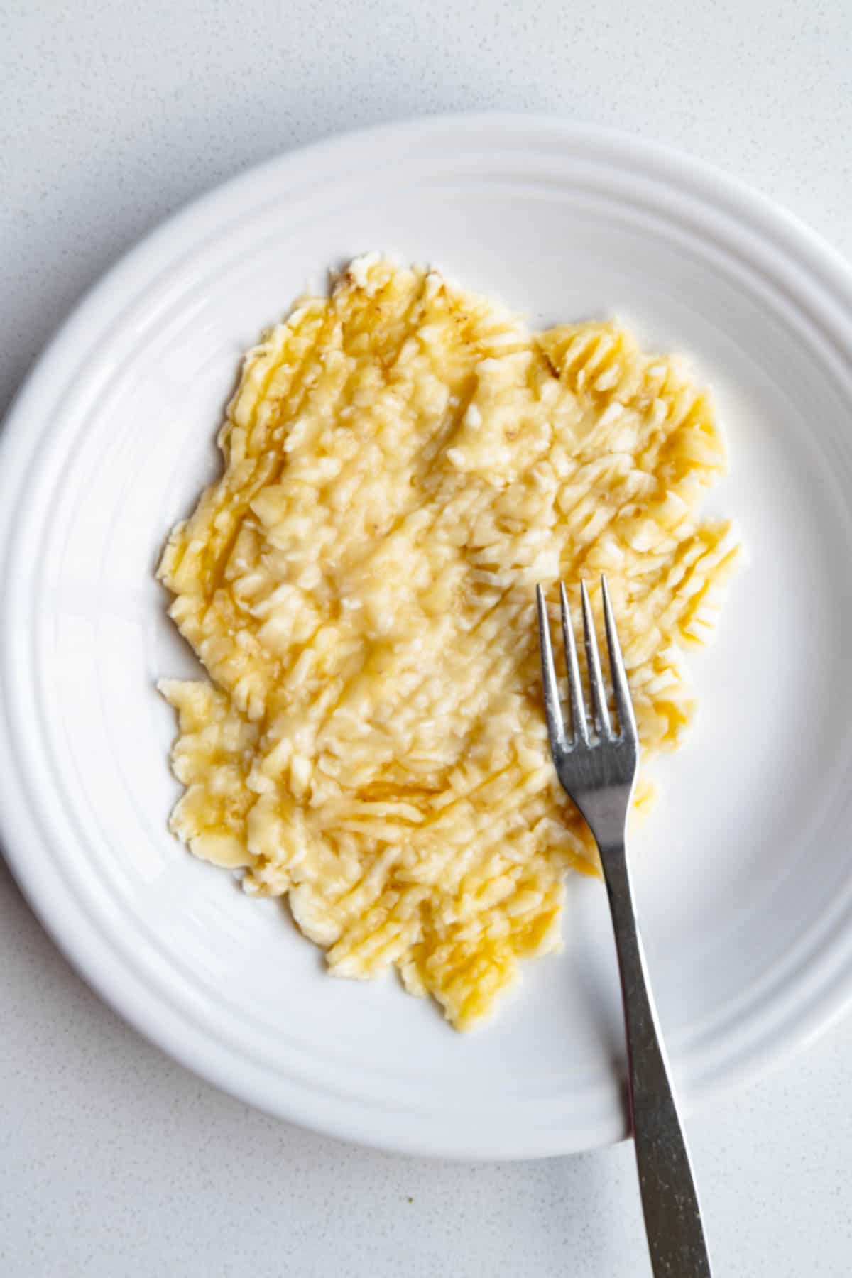 Mashed bananas on a white plate.