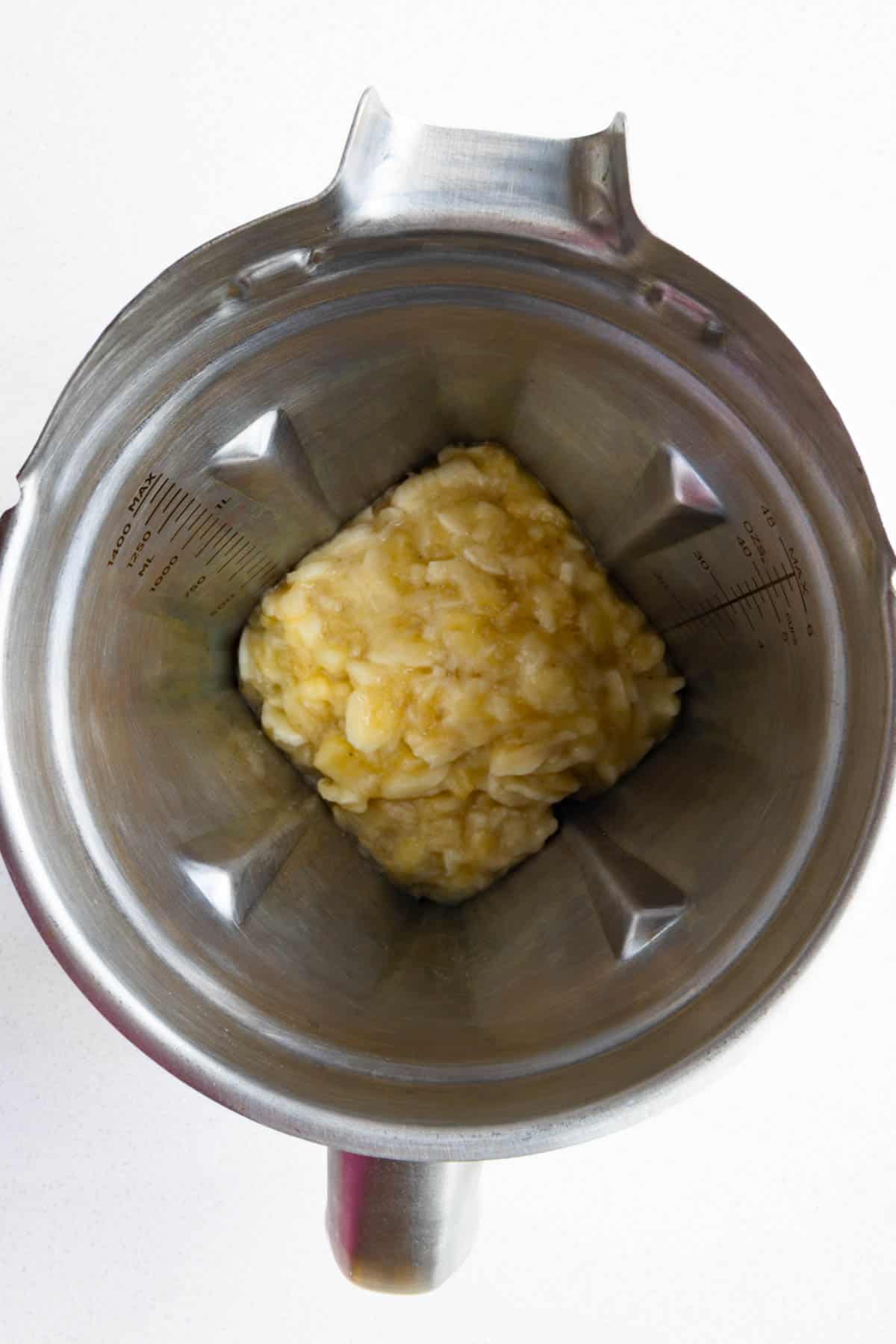 Mashed banana in the canister of a blender.