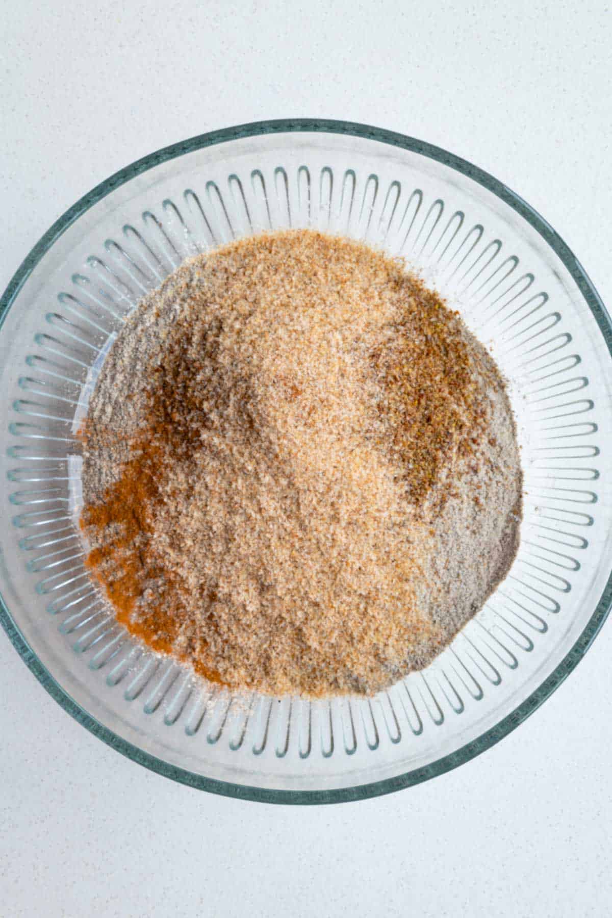 Buckwheat flour, flaxseed meal, psyllium husks, cinnamon, baking powder, and baking soda in a glass bowl.