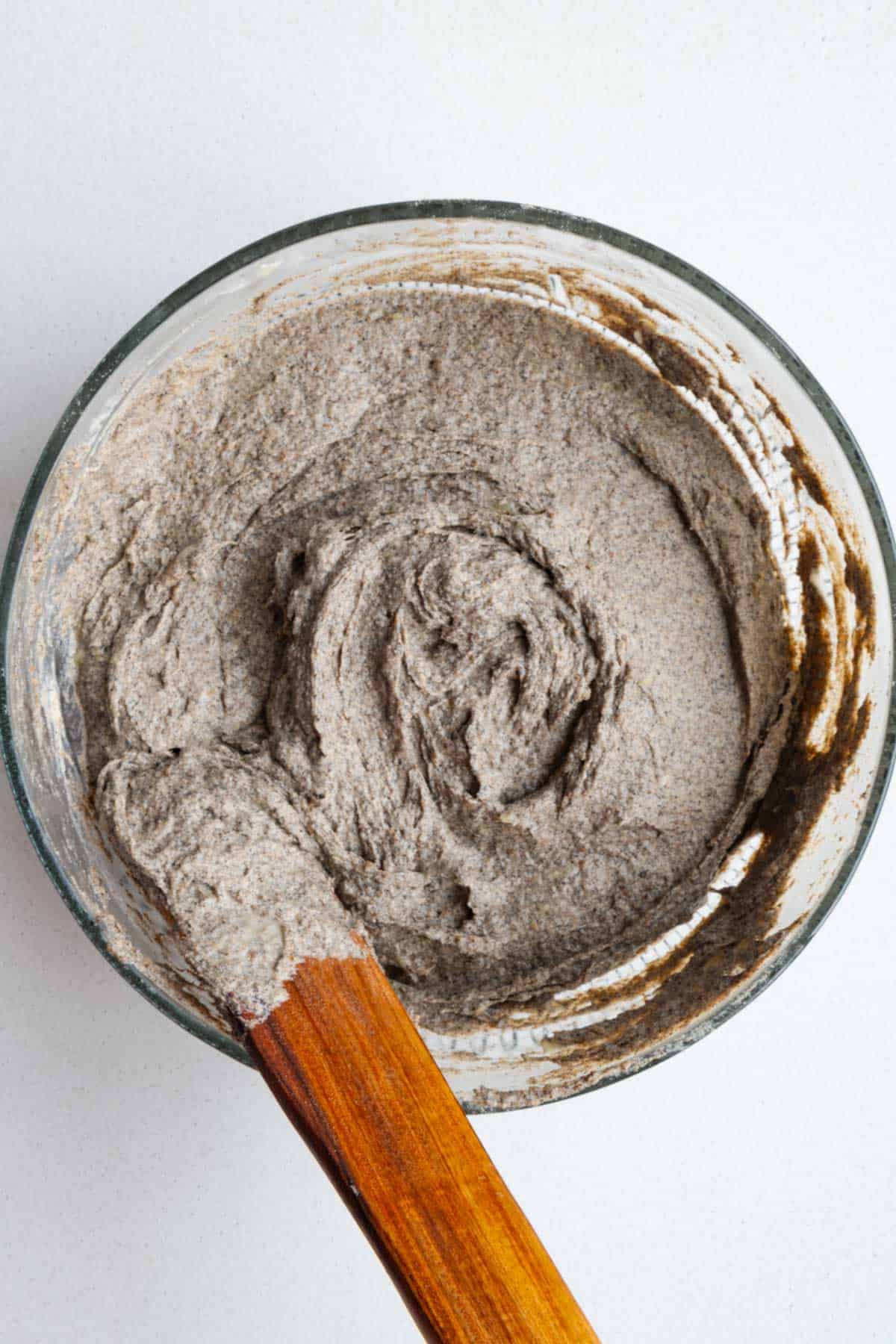 Batter in a glass bowl with a wooden spatula.