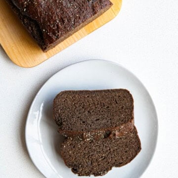 Healthy banana bread recipe on a cutting board and sliced on a plate.