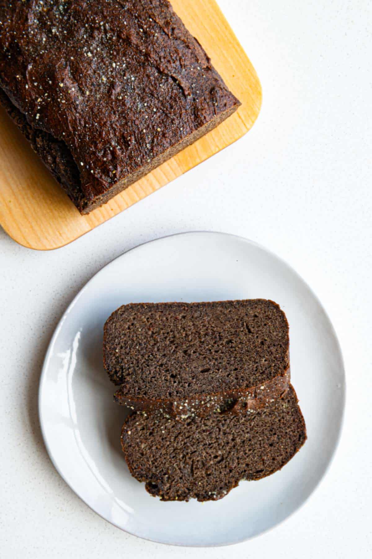 This Healthy Banana Bread is moist, tender, and naturally sweet with rich banana flavor and warm cinnamon. Made with buckwheat flour, pumpkin seeds, flaxseed, and psyllium, it's a wholesome, satisfying loaf with no oil or added sugar. For an extra-special finish, spread it with the creamy Pumpkin Seed Date Icing. Healthy banana bread sliced and plated.