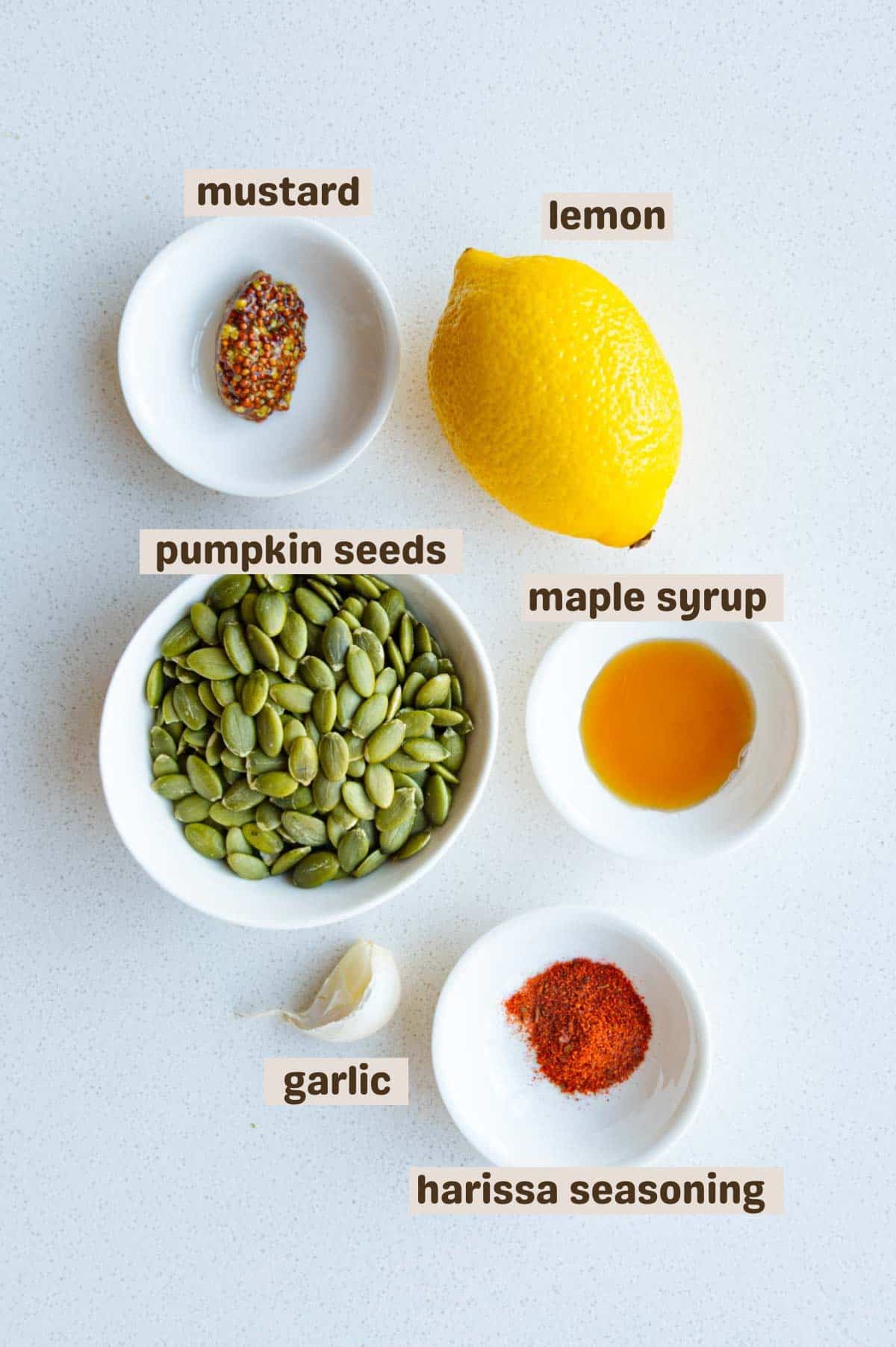 Pumpkin seeds, mustard, lemon, garlic, maple syrup, and harissa seasoning.