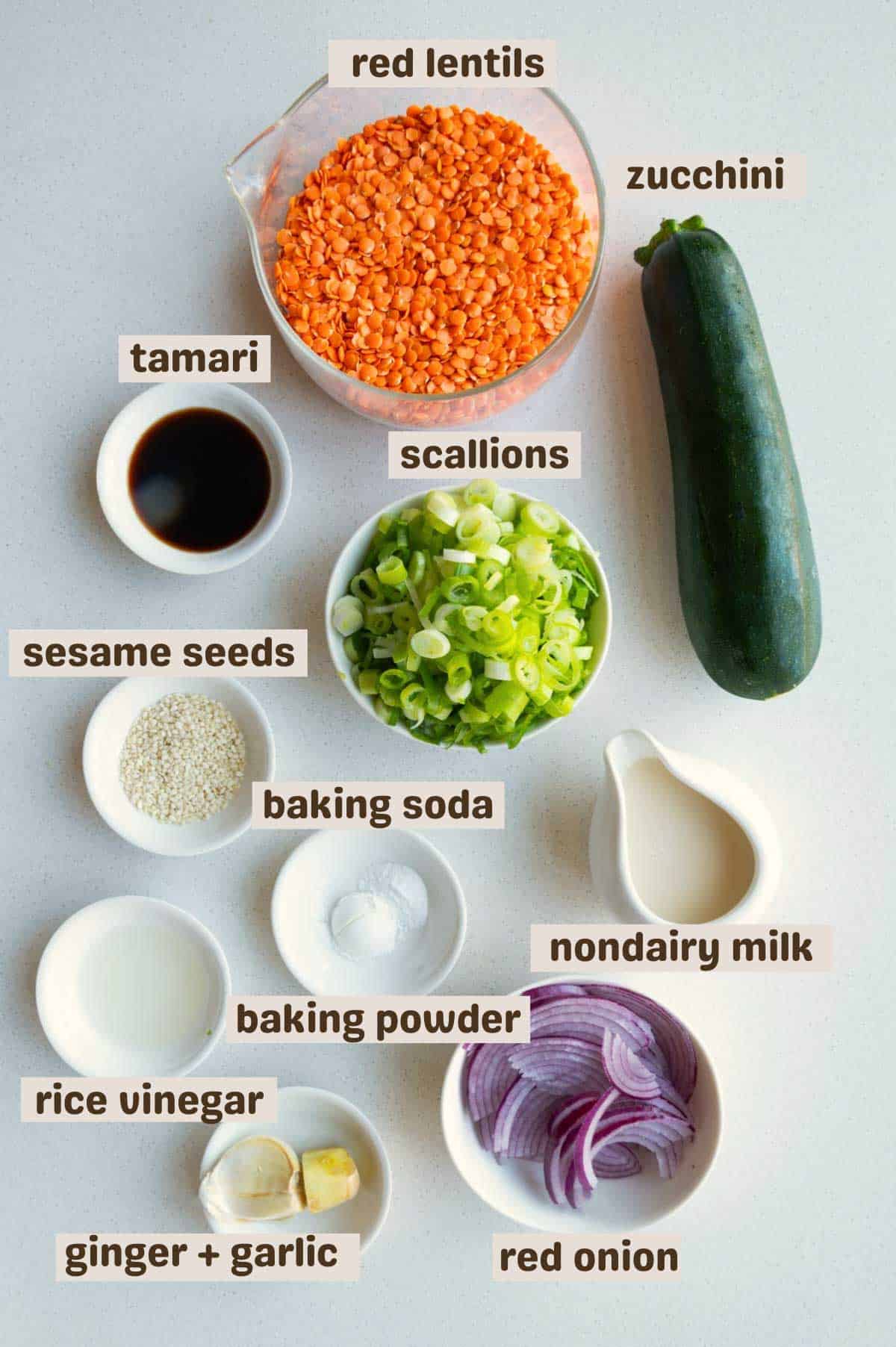 Red lentils, zucchini, baking soda, baking powder, tamari, scallions, red onion, rice vinegar, garlic, ginger, sesame seeds, and scallions.