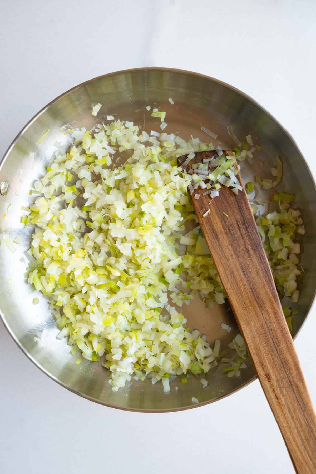 Cooked leek and onion in a large stainless skillet.