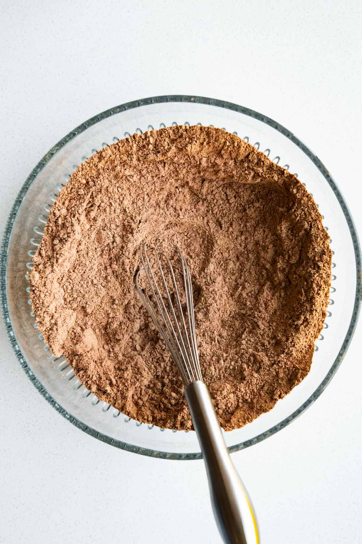 Oat flour, sorghum flour, cocoa powder, baking soda, and baking powder whisked in a bowl.