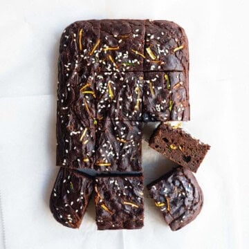 Healthy zucchini chocolate cake cut into squares on white parchment paper.