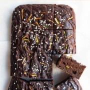 Healthy zucchini chocolate cake cut into squares on white parchment paper.