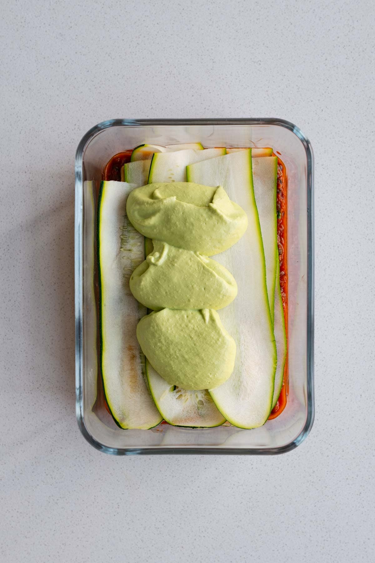 Layered vegan lasagna in a baking dish.