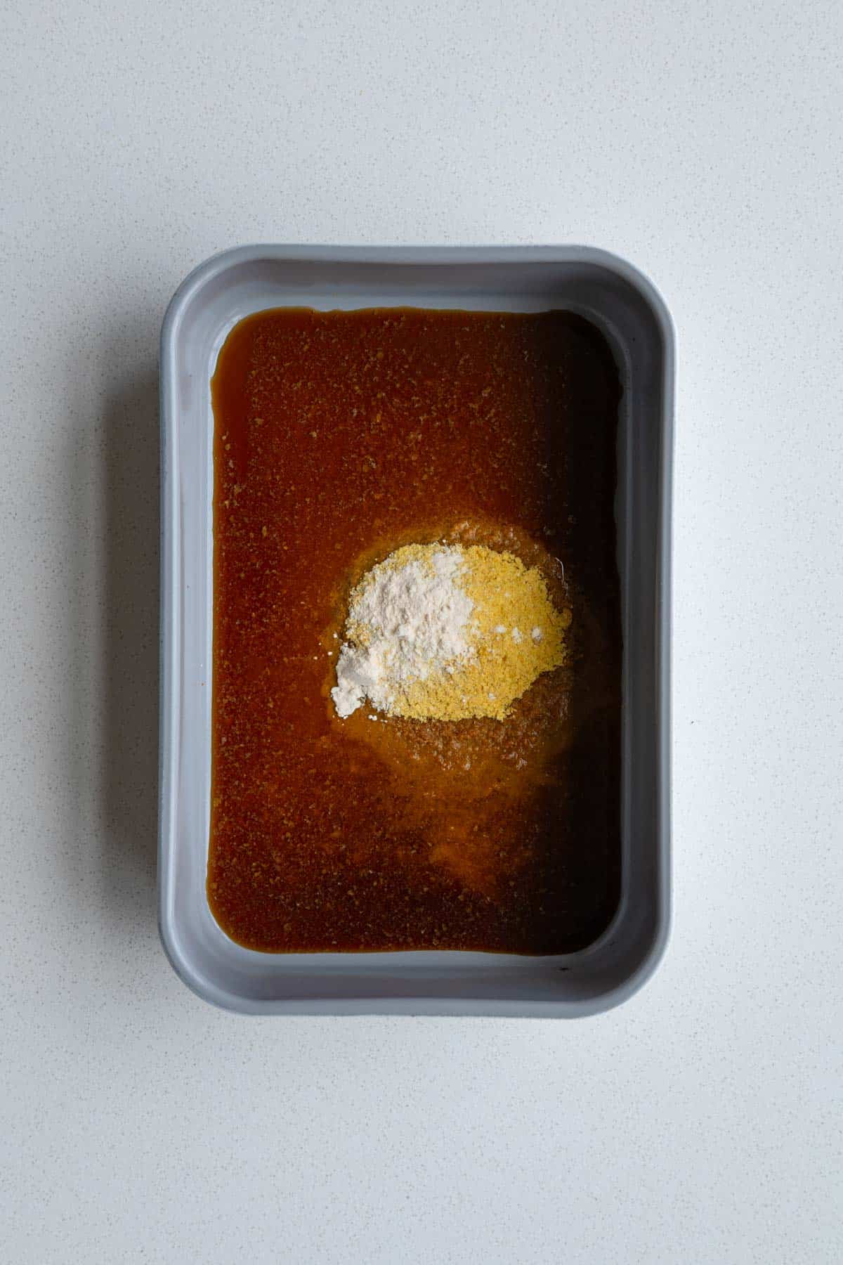 Tamari, nutritional yeast, garlic powder, and water in a baking dish.