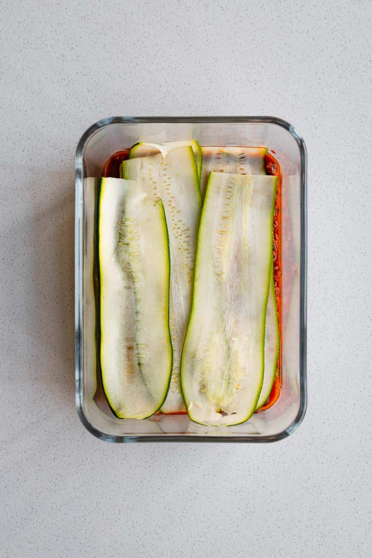 Layered vegan lasagna with zucchini in a baking dish.