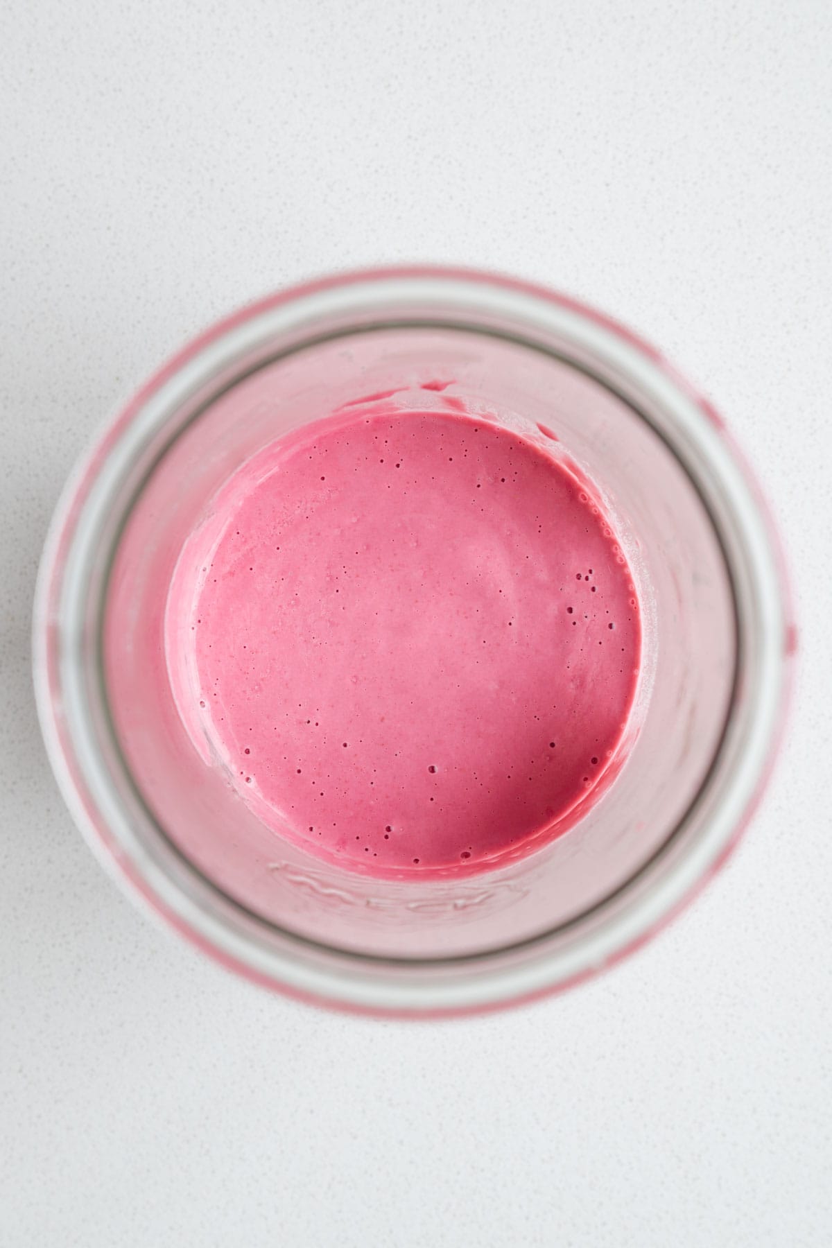 Blended beet salad dressing in a glass jar.