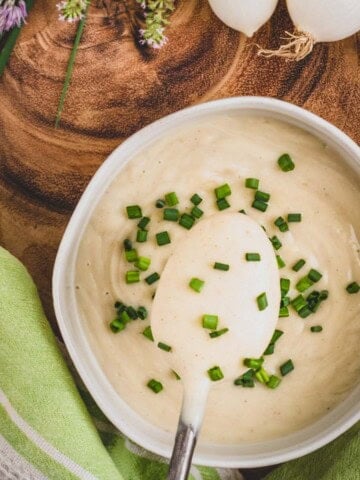 Cauliflower cream in a bowl topped with chopped chives.