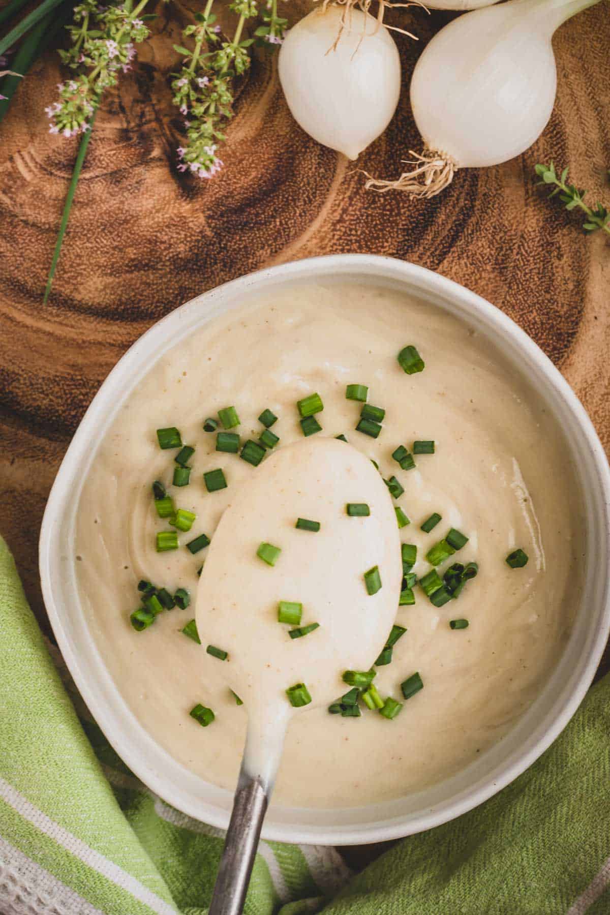Cauliflower cream in a bowl topped with chopped chives.