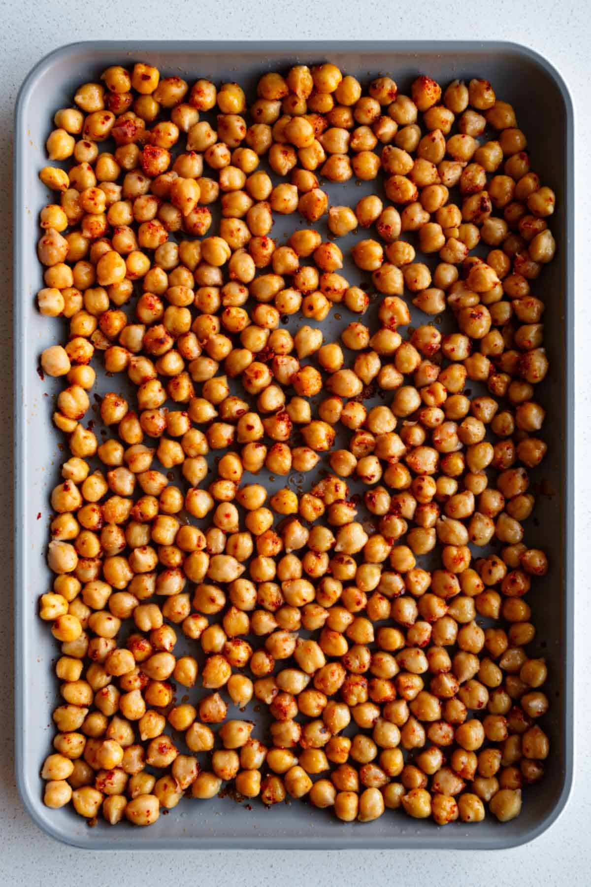 Seasoned chickpeas on a baking sheet.