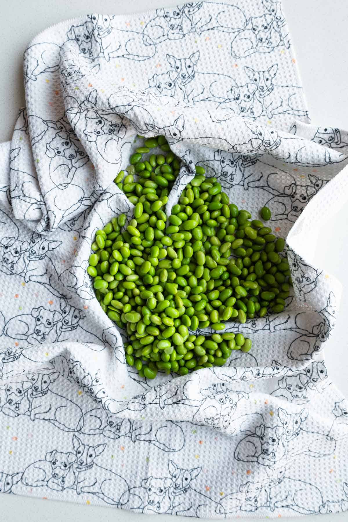 Drying the edamame in a towel before baking.