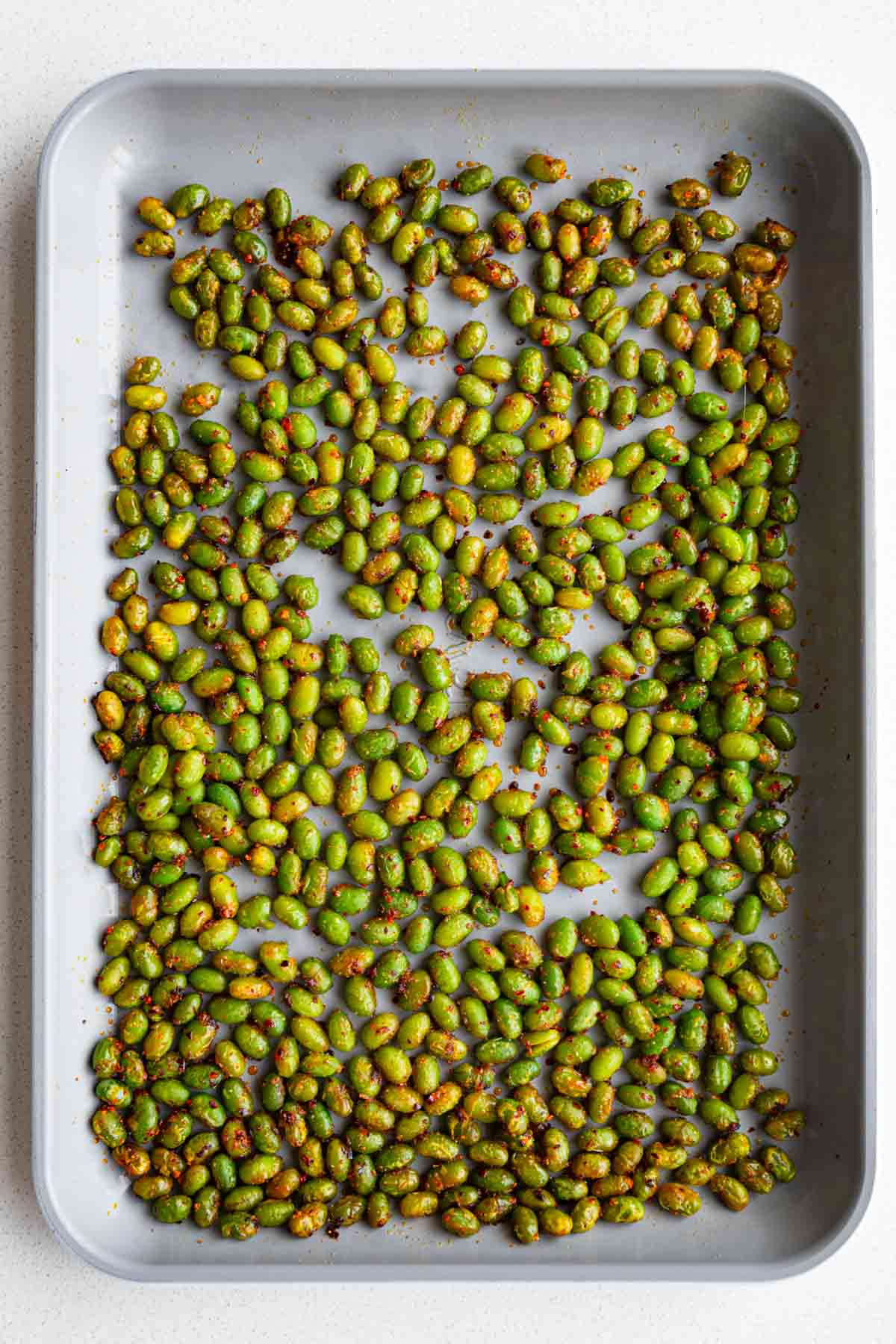 Roasted edamame on a baking sheet.