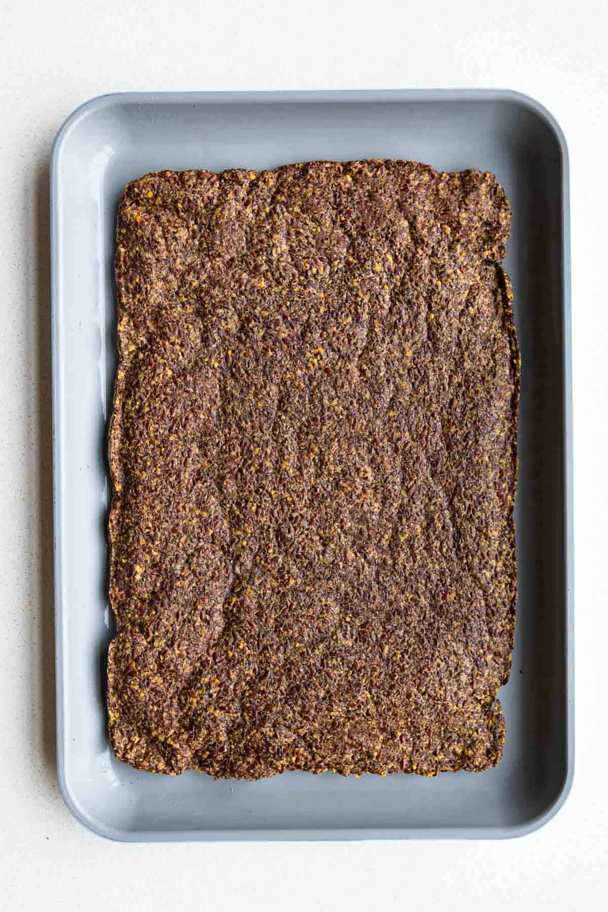 Crisp baked flaxseed cracker dough on a baking sheet.