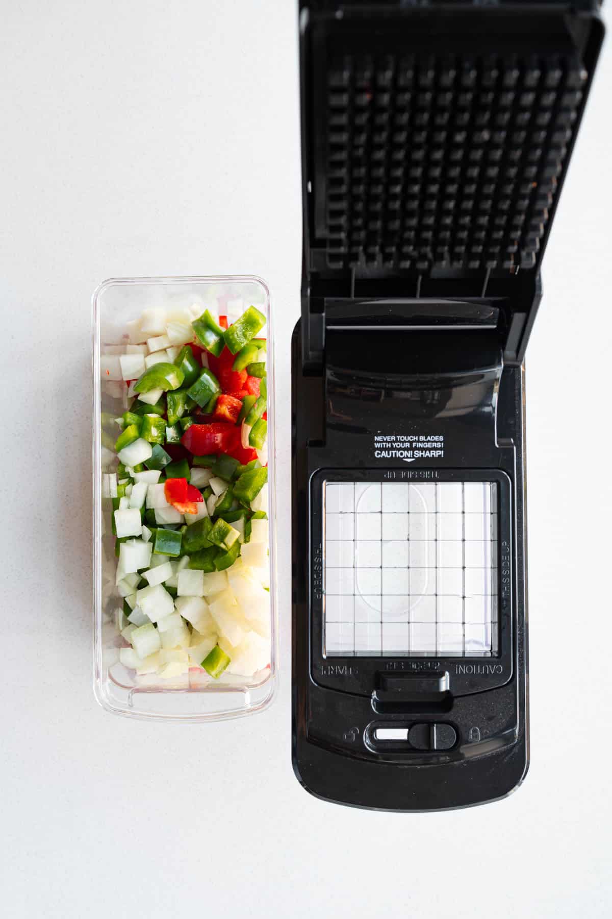 Chopped onion and bell peppers in a veggies chopper.