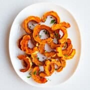 Roasted delicata squash on a white plate.