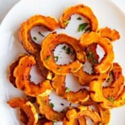 Roasted Delicata squash on a white plate.