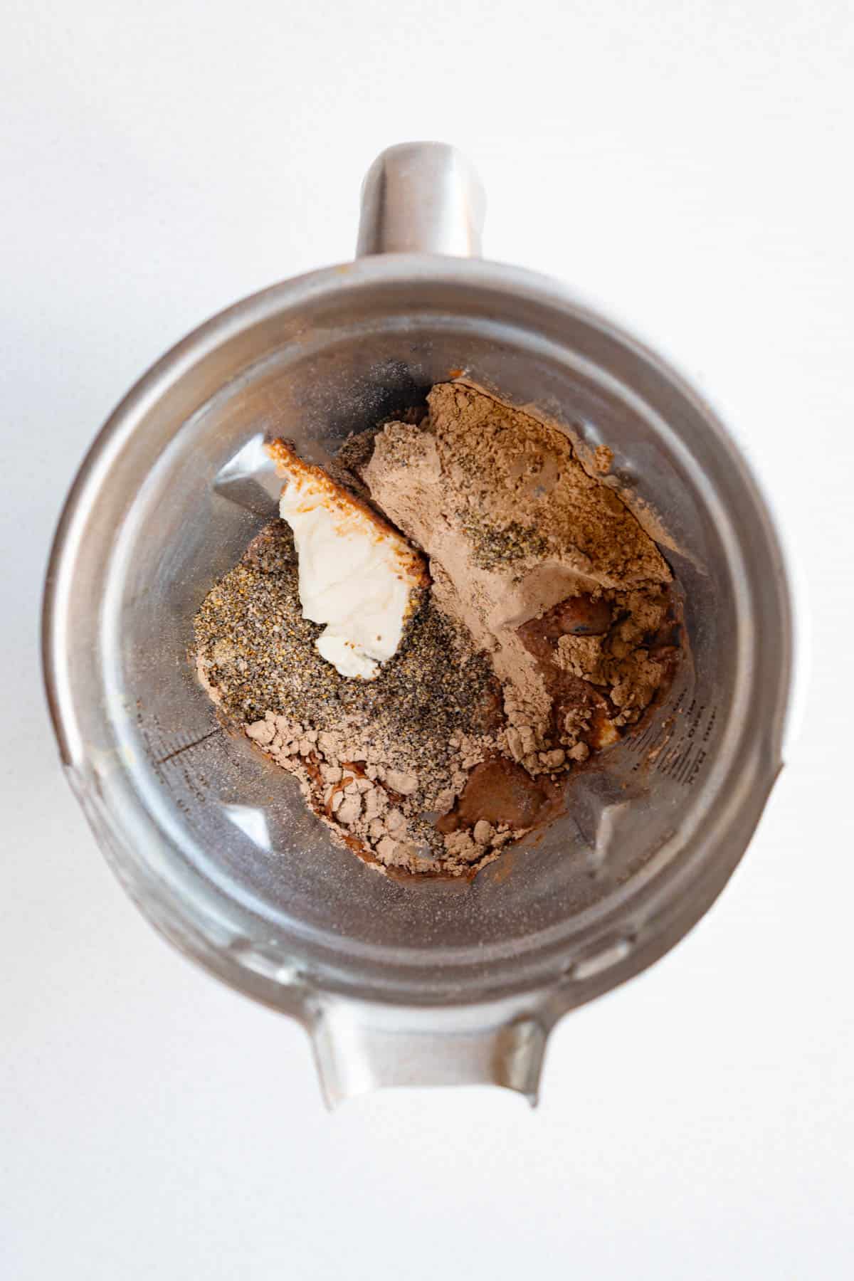Silken tofu, ground chia seeds, cocoa powder or protein powder, vanilla, cinnamon, and nondairy milk in a blender.