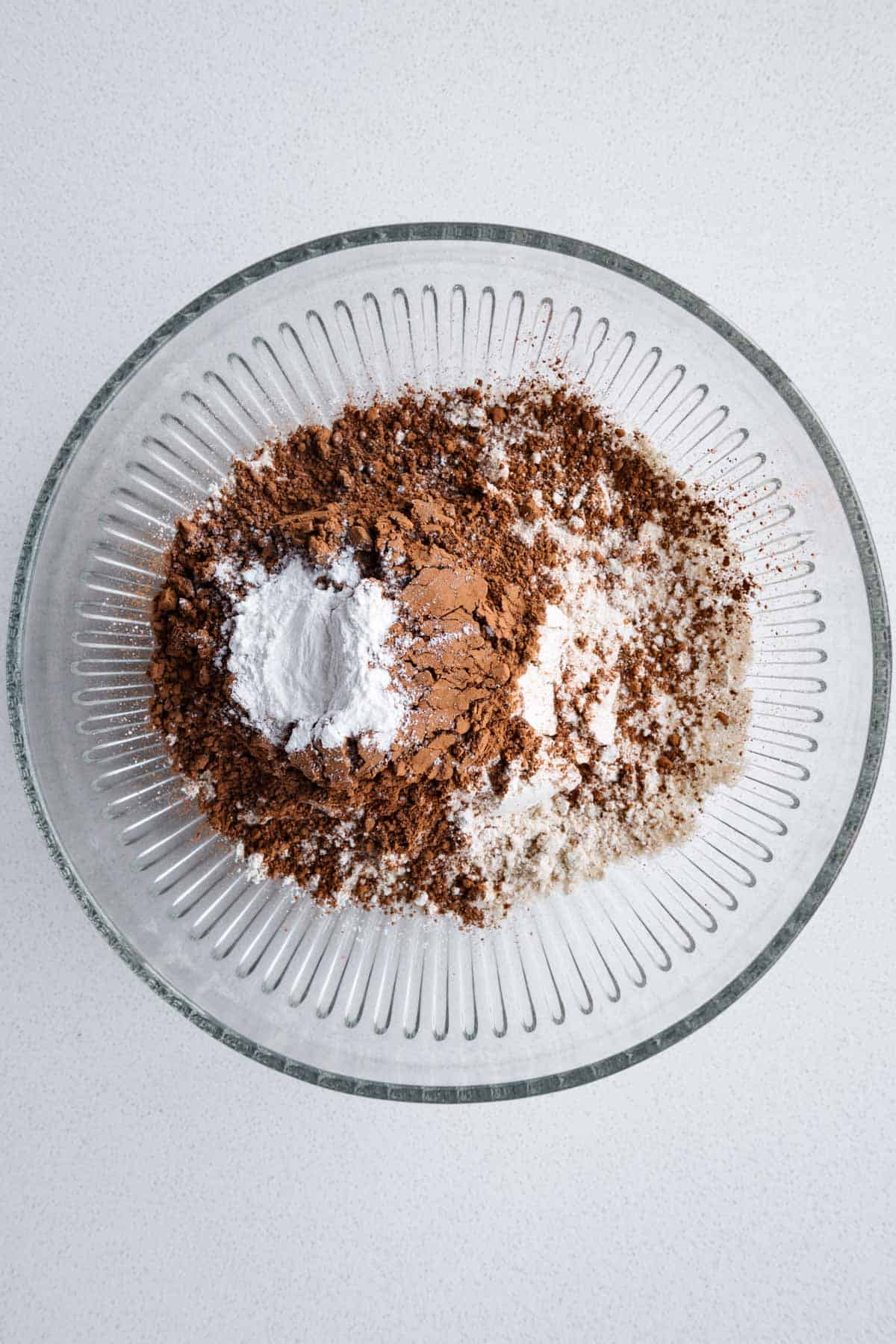Sorghum flour, oat flour, cocoa powder, and baking powder in a bowl.