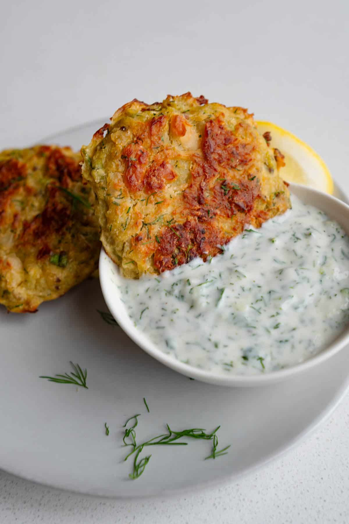 Potato fritters with vegetarian tzatziki sauce (gyro sauce) in a bowl.