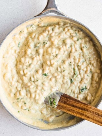 White beans in cauliflower cream sauce in a skillet.